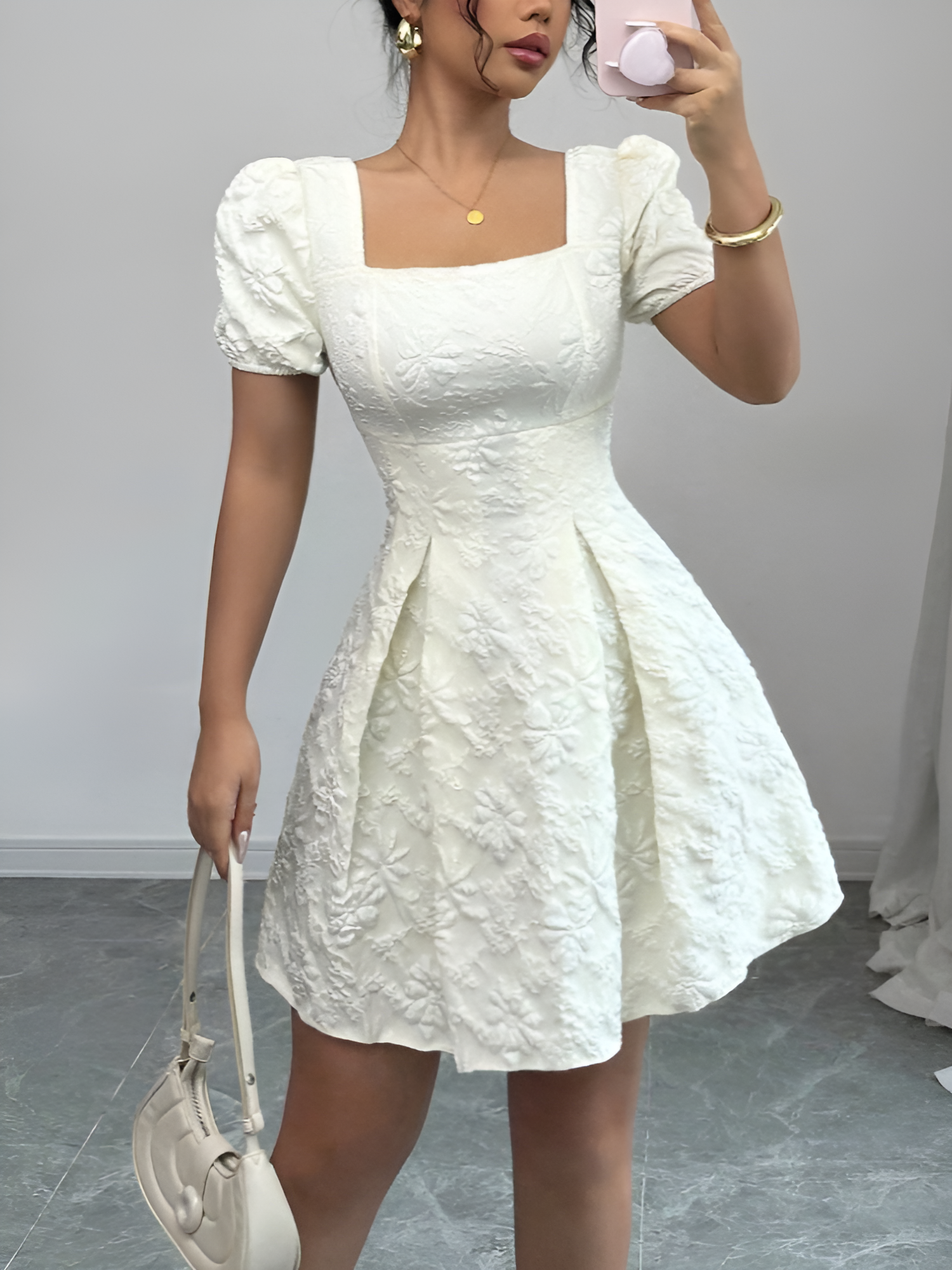 White - Model wearing a textured floral jacquard mini dress with a square neckline, short puff sleeves, and a pleated A-line skirt
