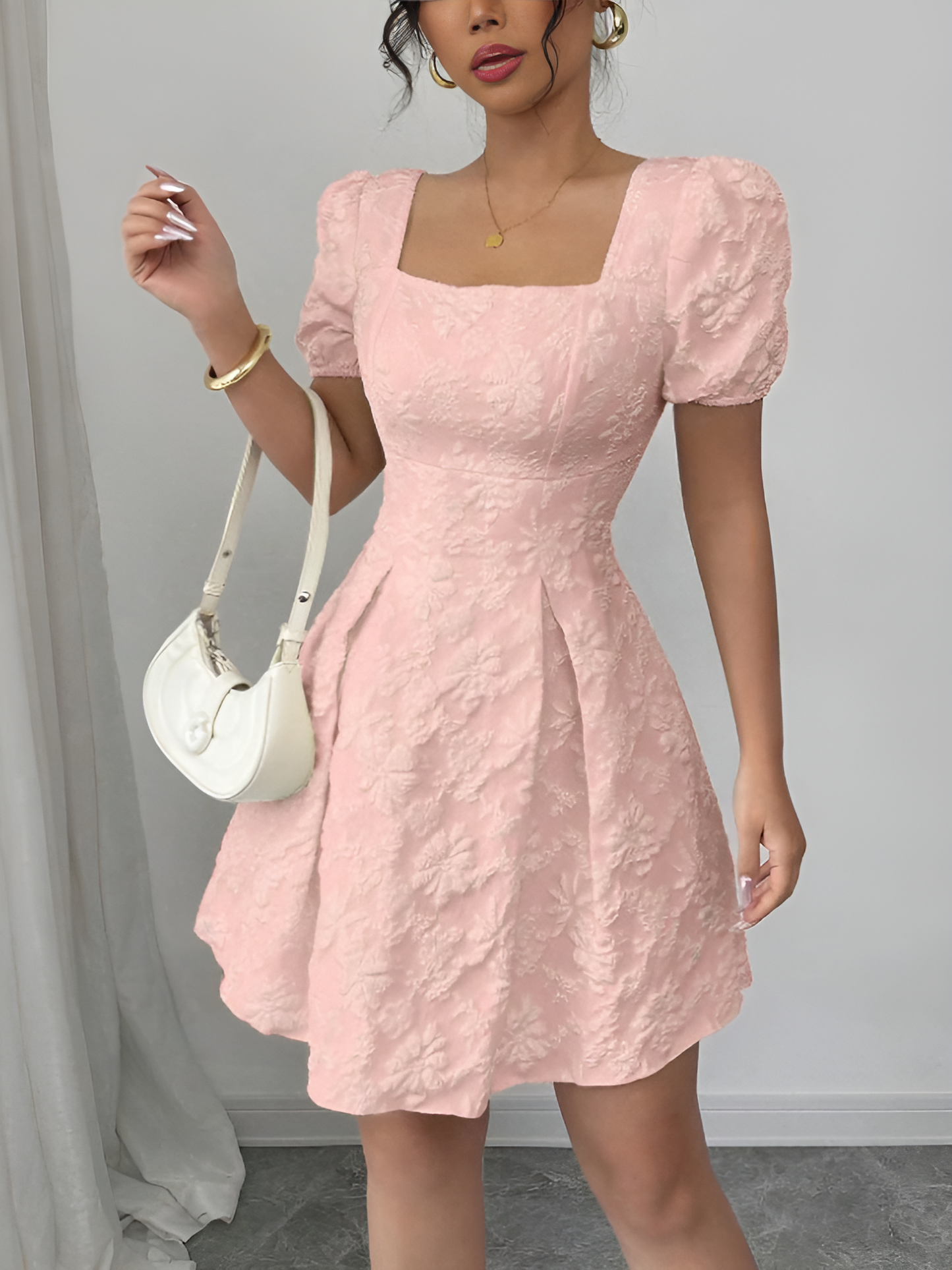 Pink - Model wearing a textured floral jacquard mini dress with a square neckline, short puff sleeves, and a pleated A-line skirt