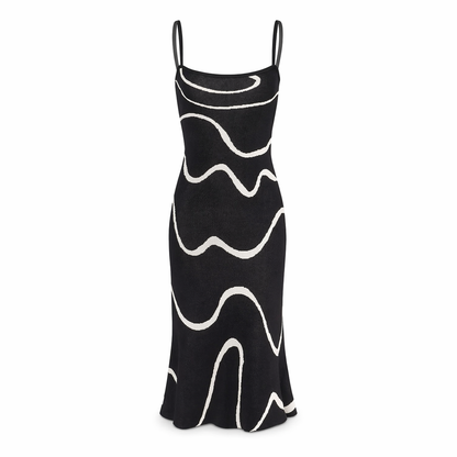Black - Model wearing a sleeveless square-neck midi dress featuring an abstract wavy line pattern, styled with an evening clutch and heels.