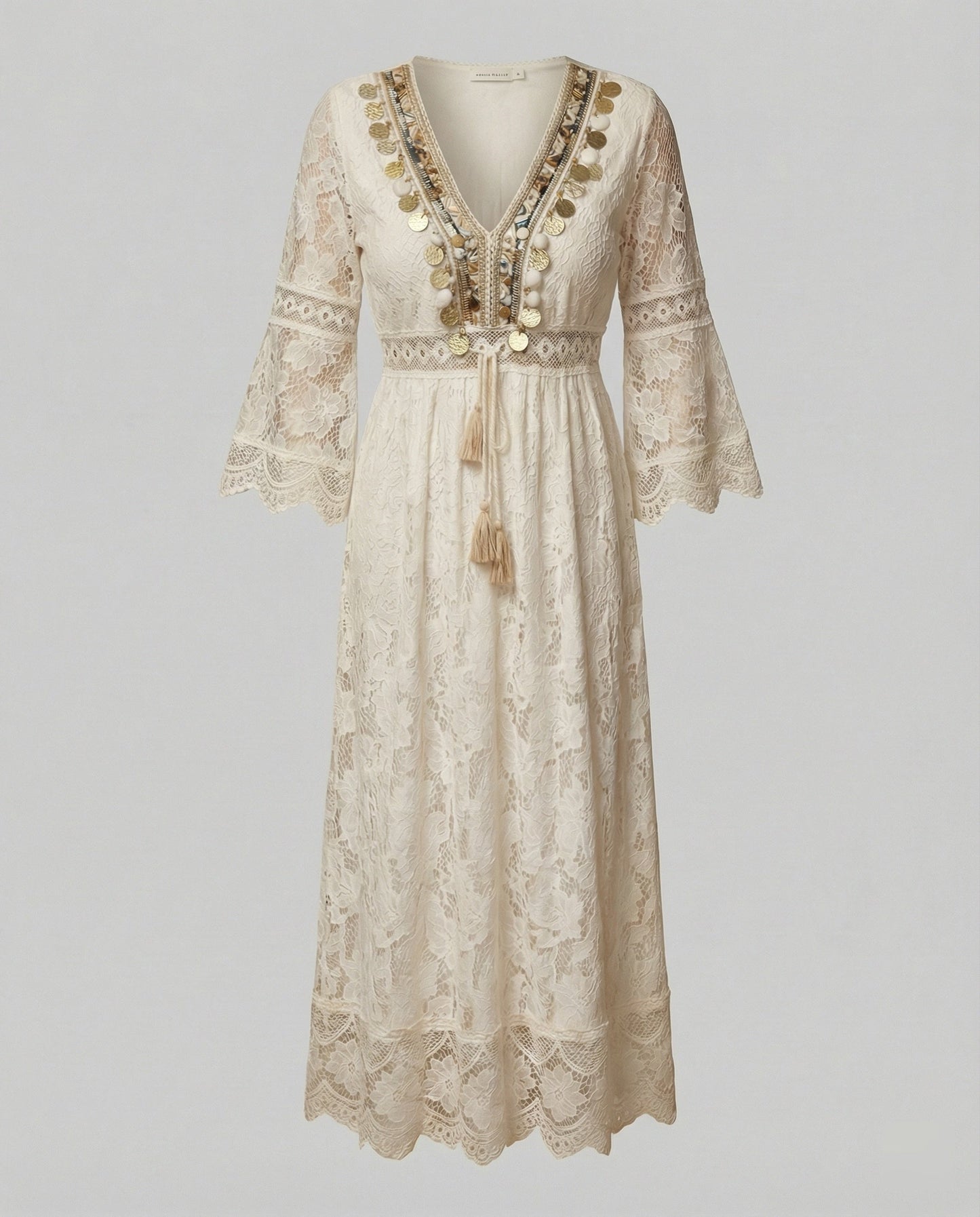 Beige - A woman wearing a bohemian lace maxi dress with a deep V-neckline, metallic embellishments, bell sleeves, and a tassel tie waist, holding a round woven bag.