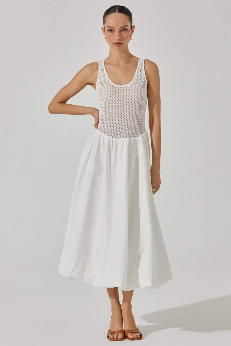 White - A woman stands against a white background wearing a sleeveless white midi dress. The dress has a textured open-knit tank-style bodice and a full, smooth A-line skirt that ends mid-calf.