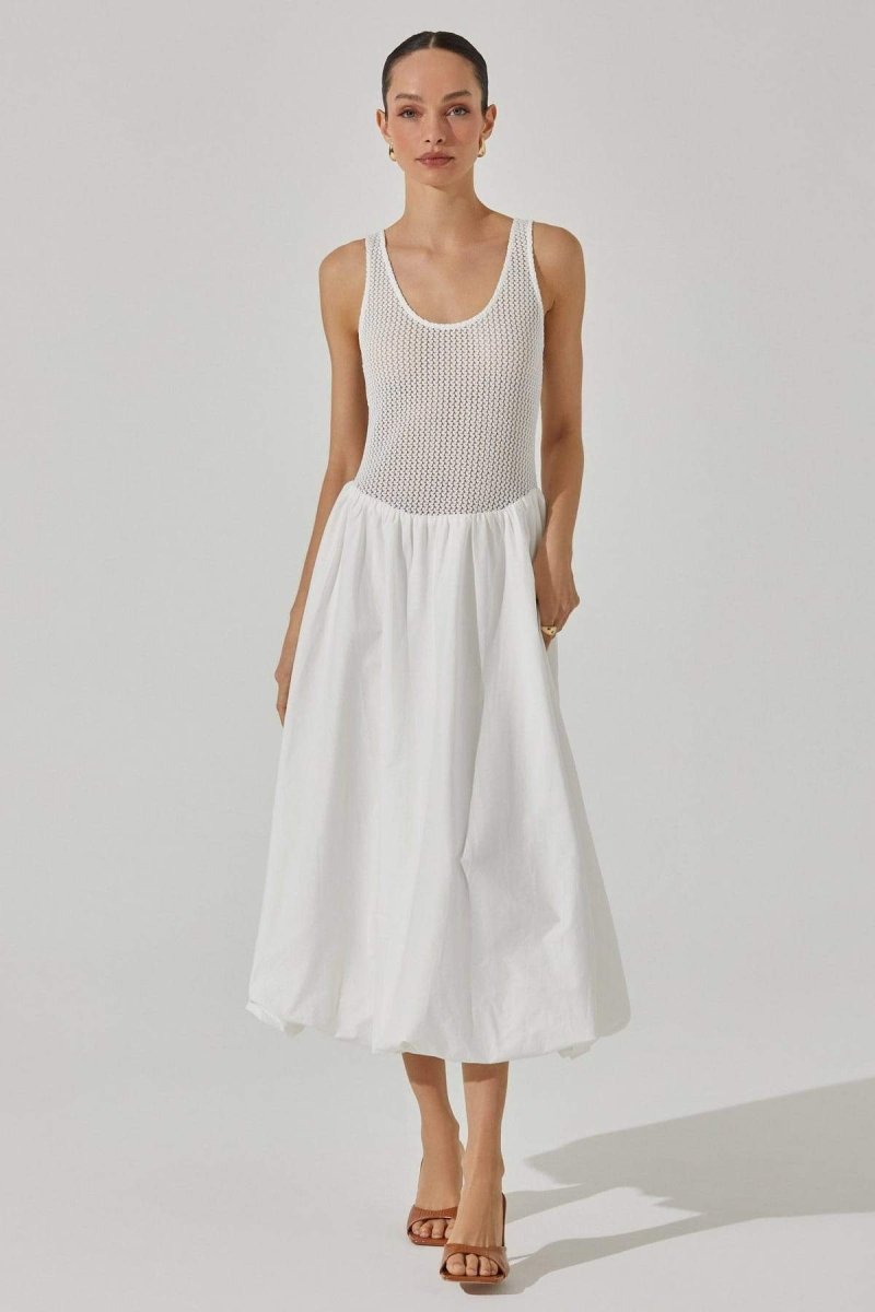White - A woman stands against a white background wearing a sleeveless white midi dress. The dress has a textured open-knit tank-style bodice and a full, smooth A-line skirt that ends mid-calf.