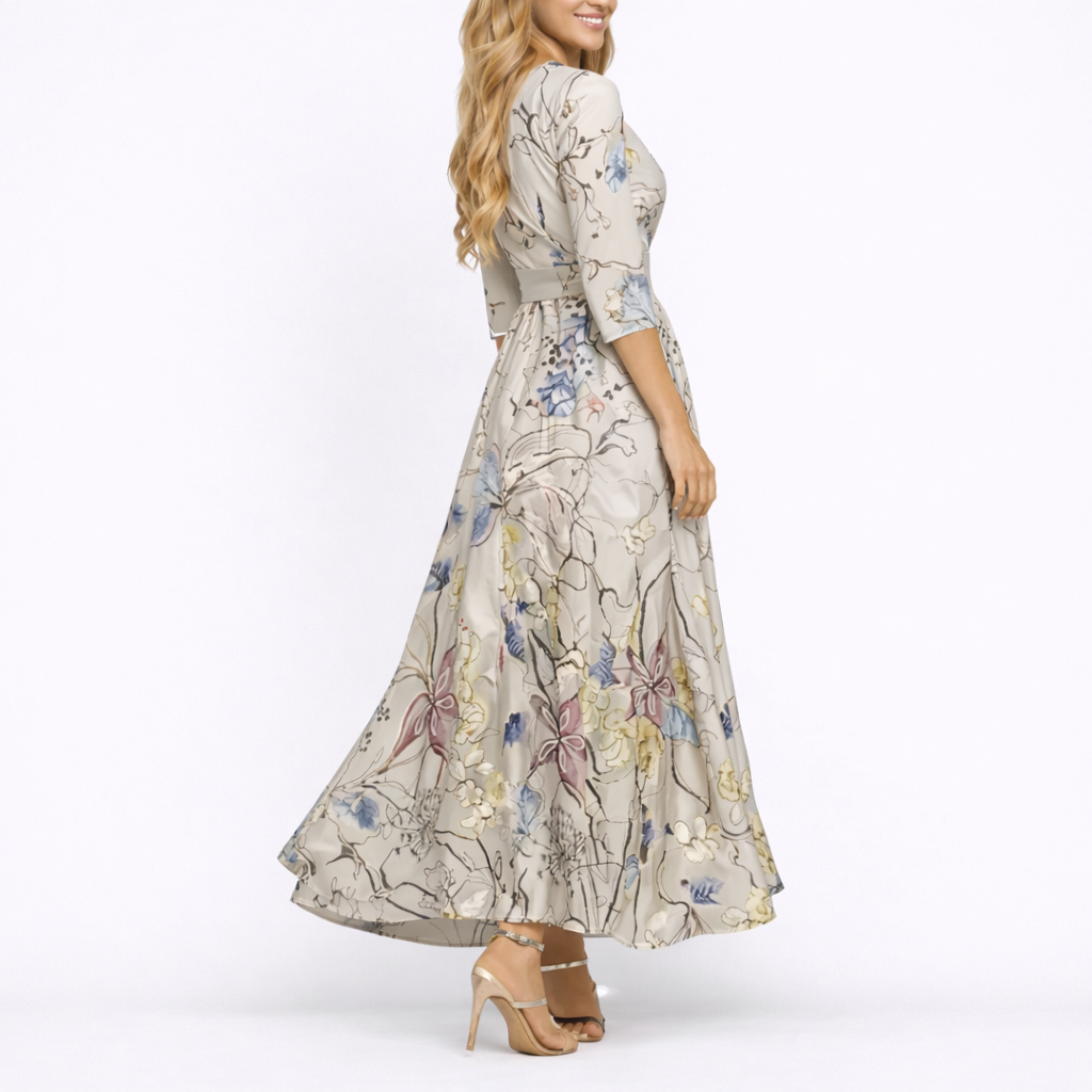 Sand & Beige - Woman wearing a long satin floral maxi dress with 3/4 sleeves, a V-neckline, and a sweeping A-line skirt.