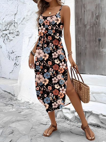 Mixed Colors - Model wearing a lightweight woven strappy midi dress with an abstract vertical pattern, adjustable waist tie, and side split, standing outdoors against a white textured wall.