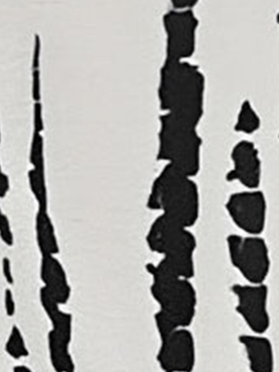 White - Model wearing a lightweight woven strappy midi dress with an abstract vertical pattern, adjustable waist tie, and side split, standing outdoors against a white textured wall.