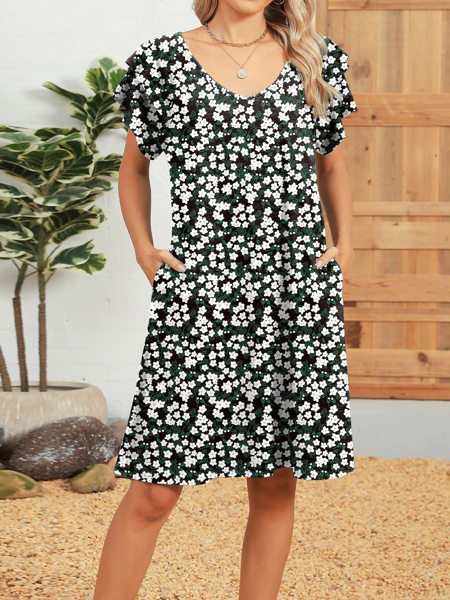 Black White - Woman wearing a lightweight woven animal-print shift dress with a V-neckline and short flutter sleeves, styled with a woven bag.