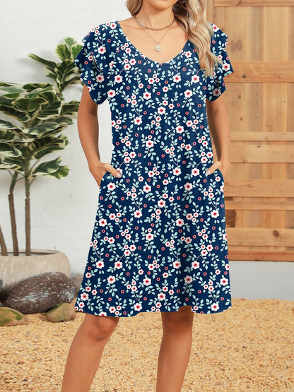 Blue - Woman wearing a lightweight woven animal-print shift dress with a V-neckline and short flutter sleeves, styled with a woven bag.