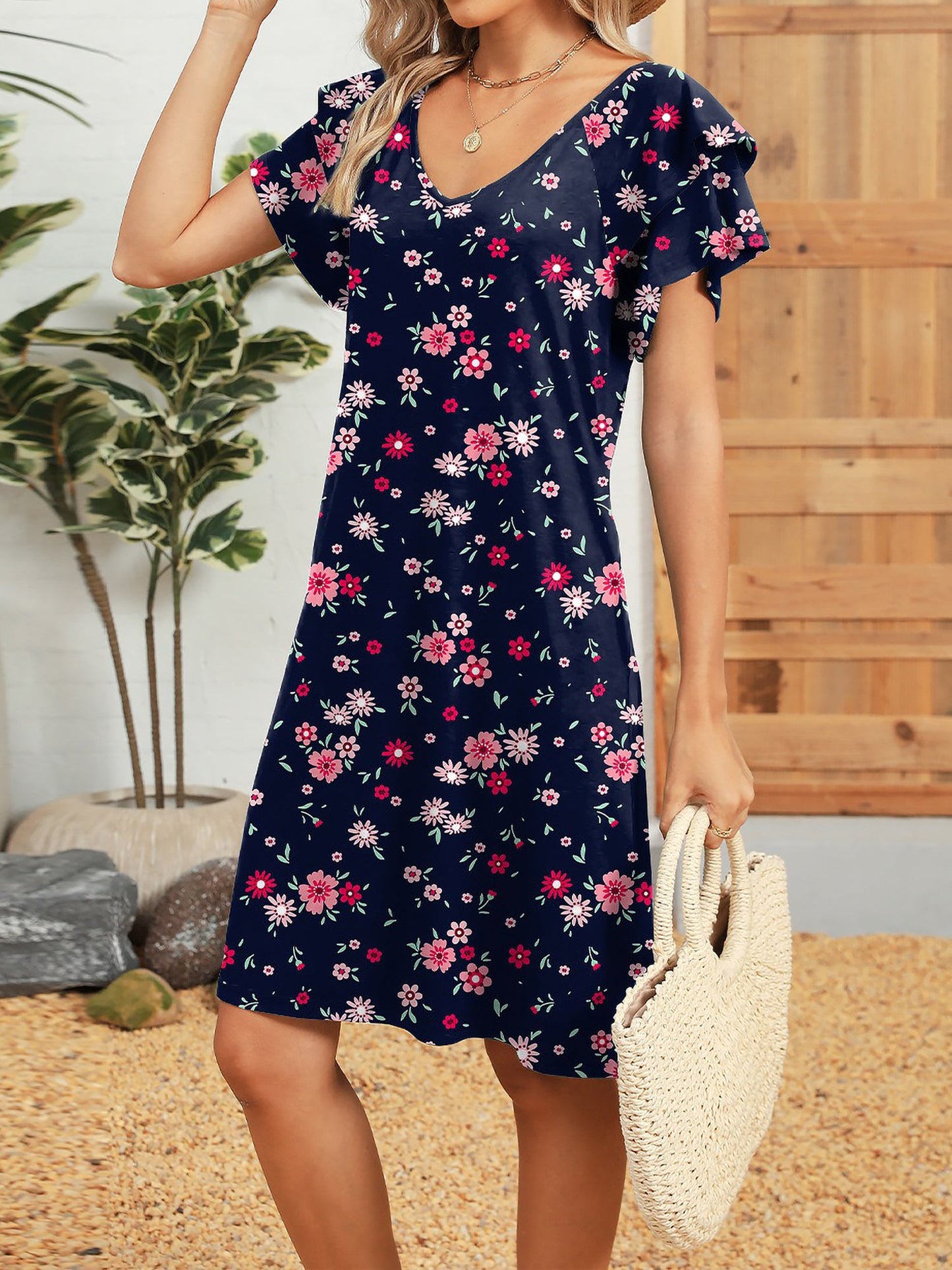 Dark Blue - Woman wearing a lightweight woven animal-print shift dress with a V-neckline and short flutter sleeves, styled with a woven bag.