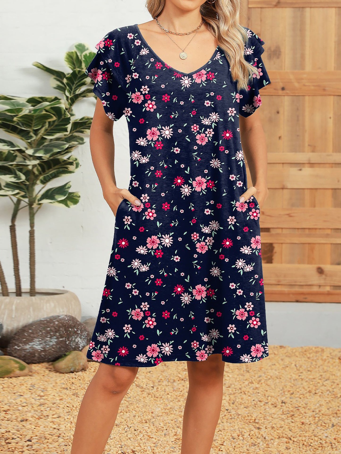 Dark Blue - Woman wearing a lightweight woven animal-print shift dress with a V-neckline and short flutter sleeves, styled with a woven bag.