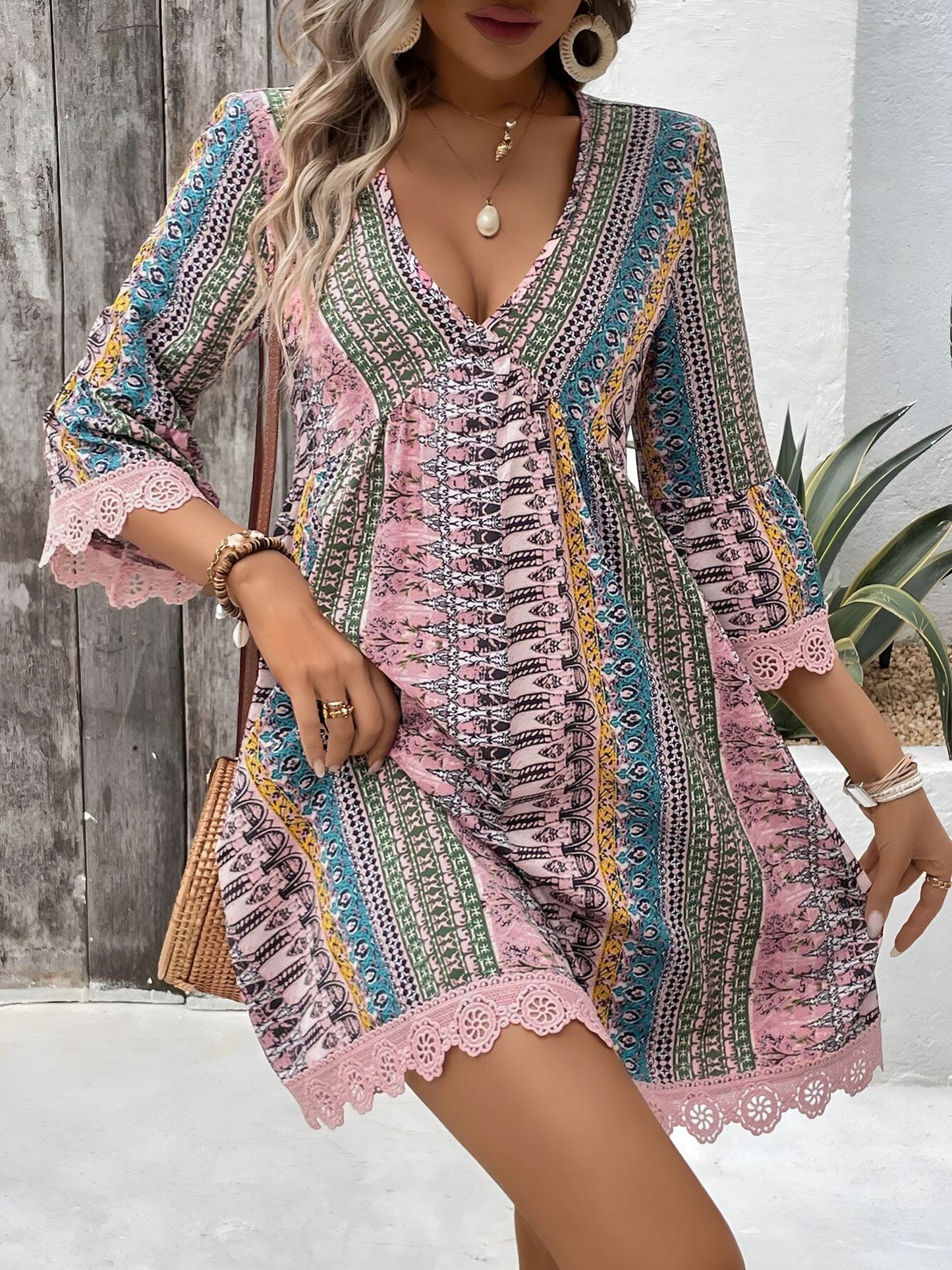 Pink - Woman wearing a patterned V-neck mini dress with 3/4 sleeves and lace trim detailing