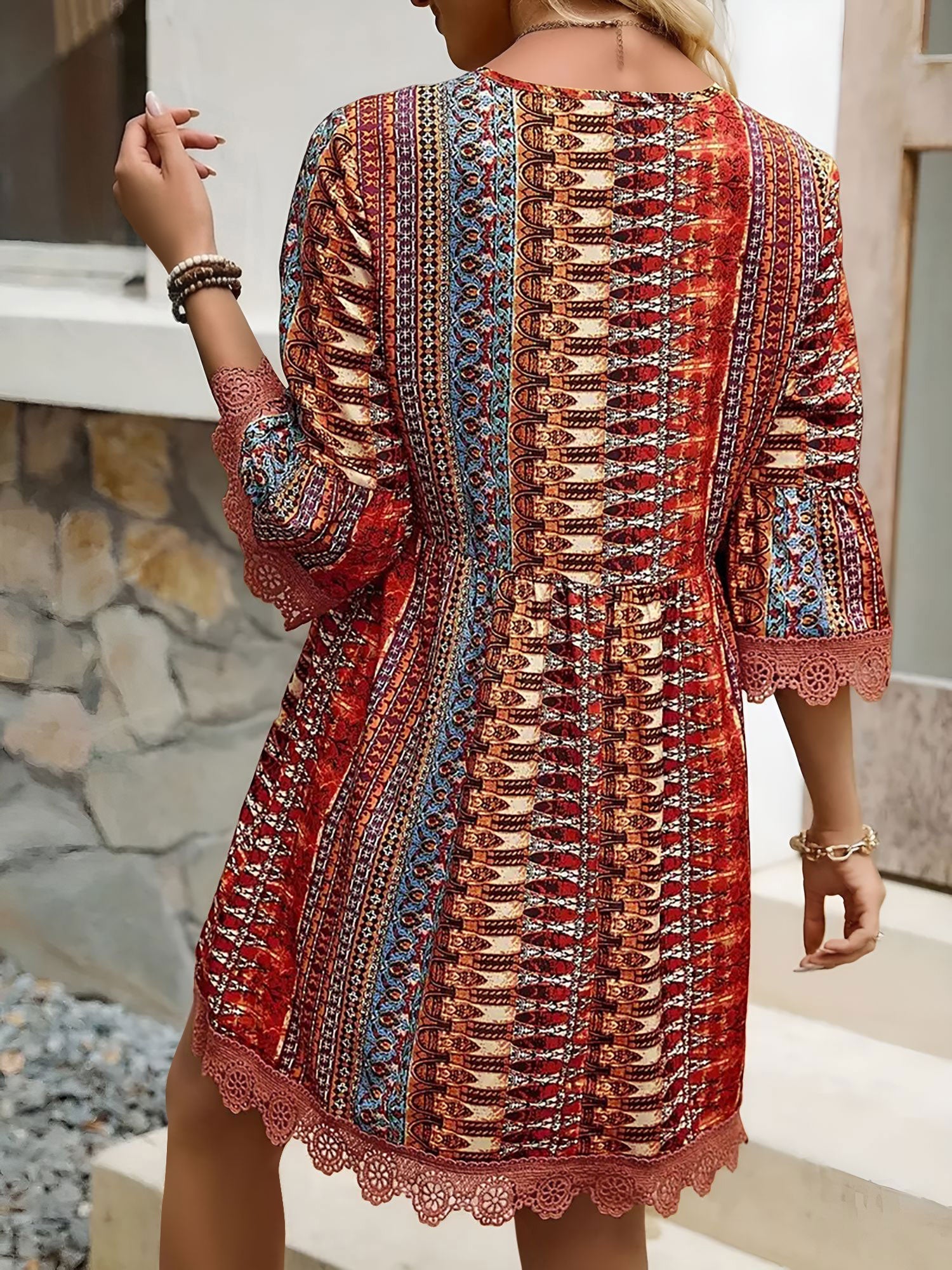 Red - Woman wearing a patterned V-neck mini dress with 3/4 sleeves and lace trim detailing
