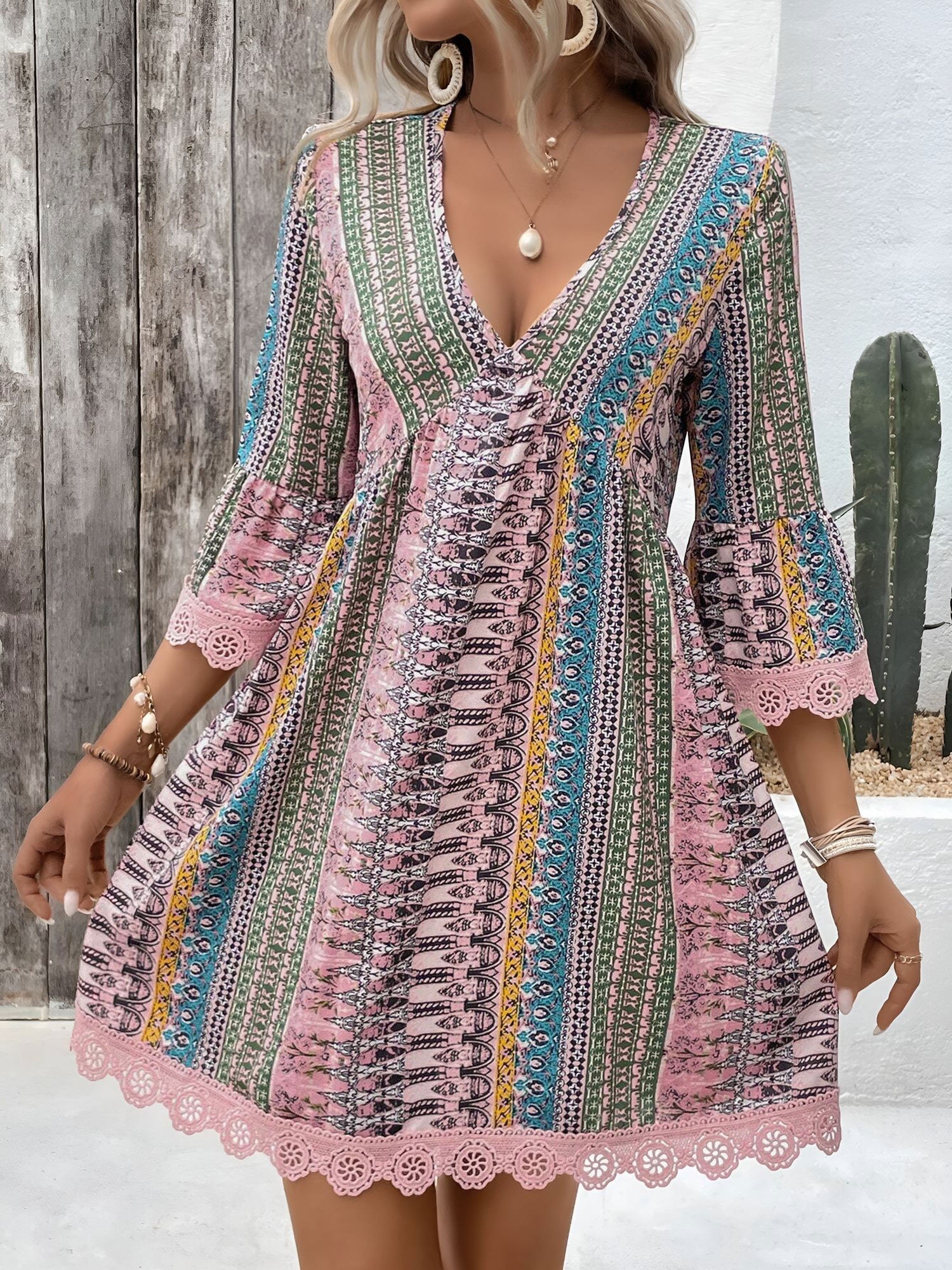 Pink - Woman wearing a patterned V-neck mini dress with 3/4 sleeves and lace trim detailing