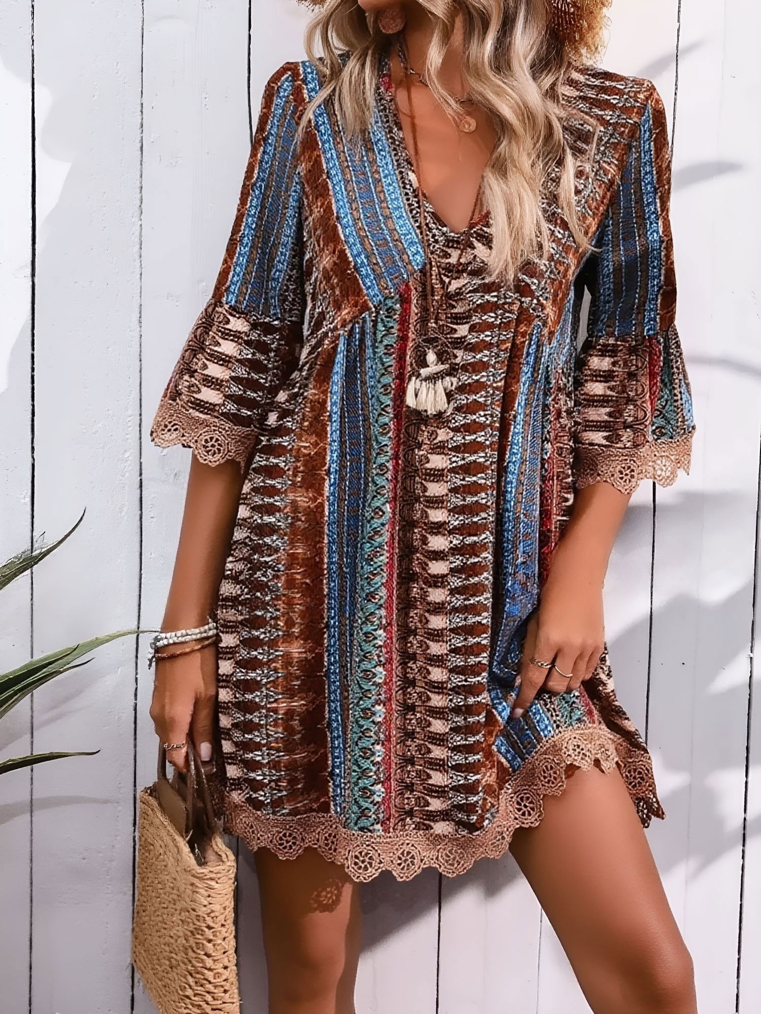 Coffee - Woman wearing a patterned V-neck mini dress with 3/4 sleeves and lace trim detailing