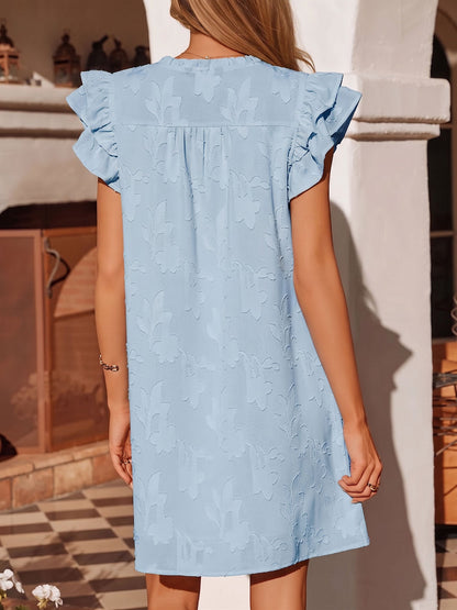 Light Blue - Woman wearing a woven mini dress with a raised floral pattern, ruffle sleeves, and a notch neckline, standing outdoors