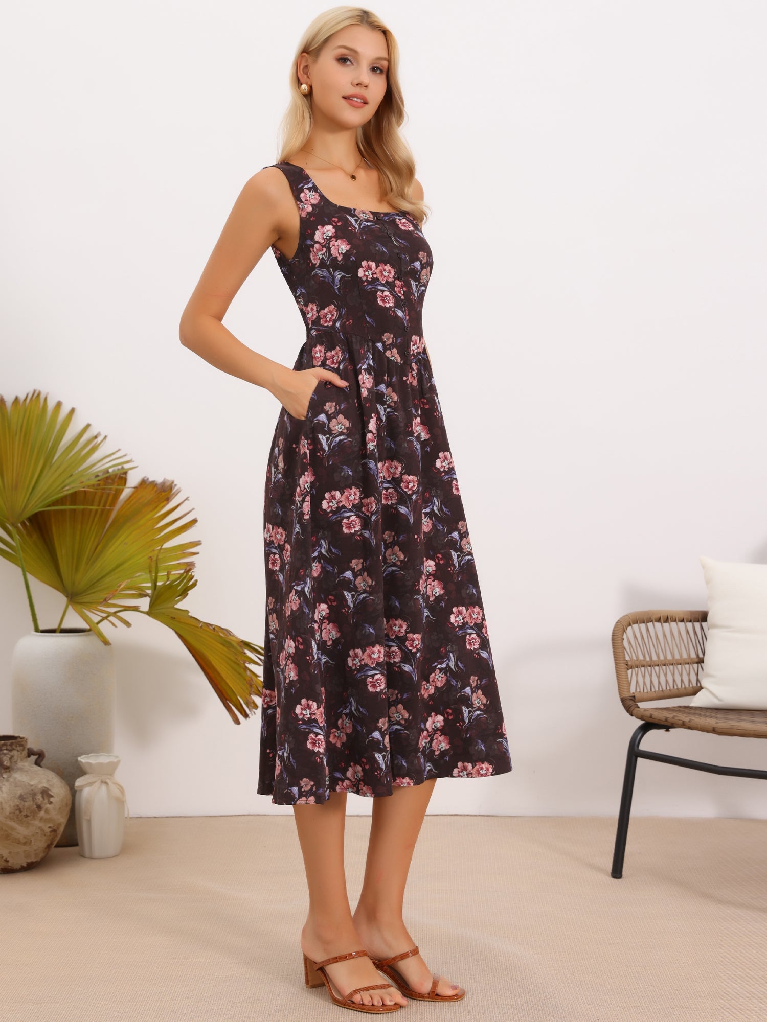 Brown Red Floral - Model wearing a sleeveless floral A-line midi dress with a square neckline and front button detailing, posing in a bright studio setting.