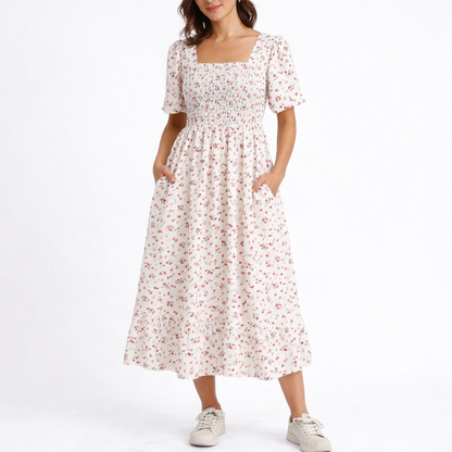White - Model wearing a woven floral square-neck midi dress with a smocked bodice, short sleeves, and a ruffle hemline.