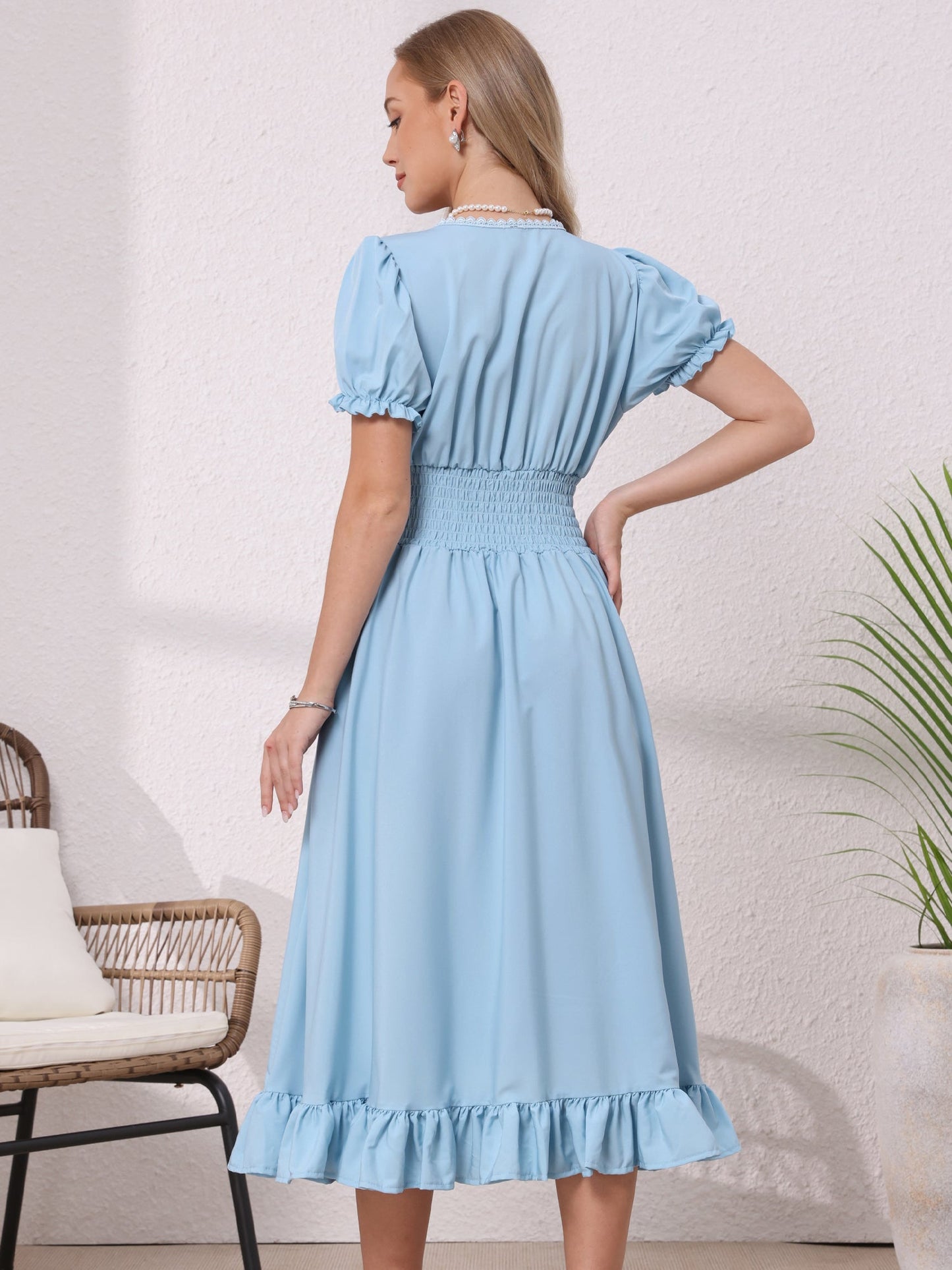 Light Blue - Model wearing a solid woven midi dress featuring a square neckline, short puff sleeves, a wide smocked waist, and a dramatic ruched front with an asymmetrical ruffled hem.