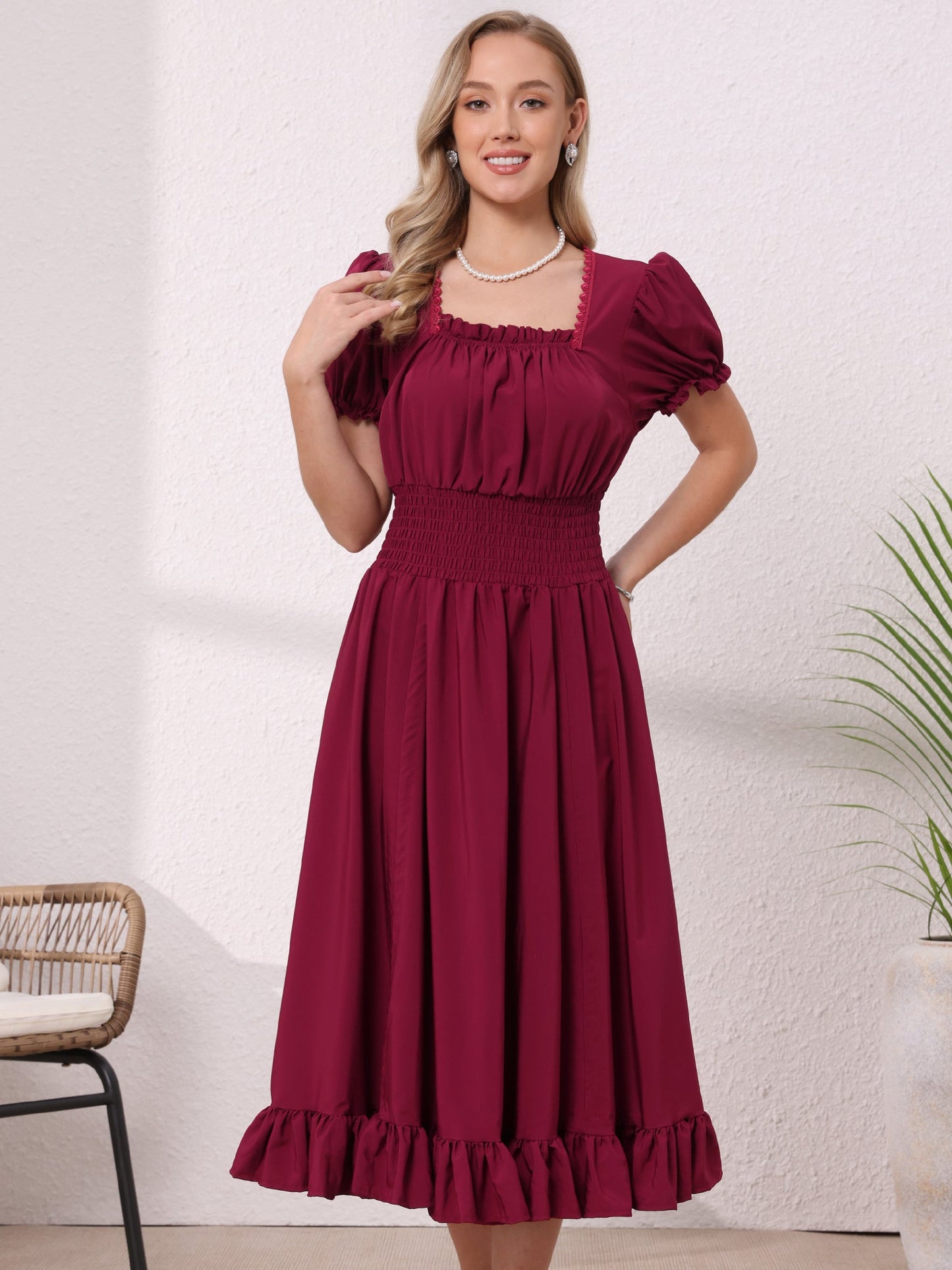 Burgundy - Model wearing a solid woven midi dress featuring a square neckline, short puff sleeves, a wide smocked waist, and a dramatic ruched front with an asymmetrical ruffled hem.