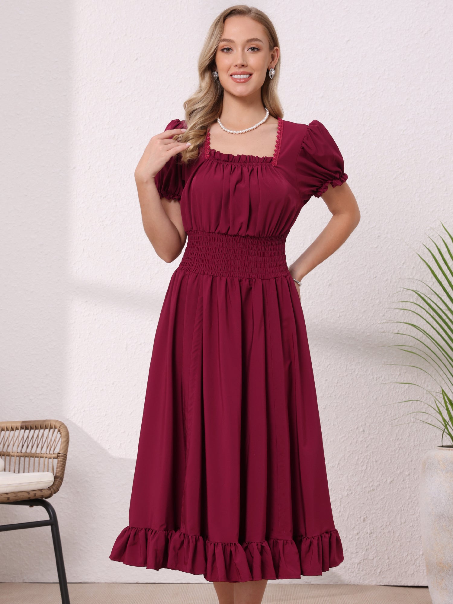 Burgundy - Model wearing a solid woven midi dress featuring a square neckline, short puff sleeves, a wide smocked waist, and a dramatic ruched front with an asymmetrical ruffled hem.