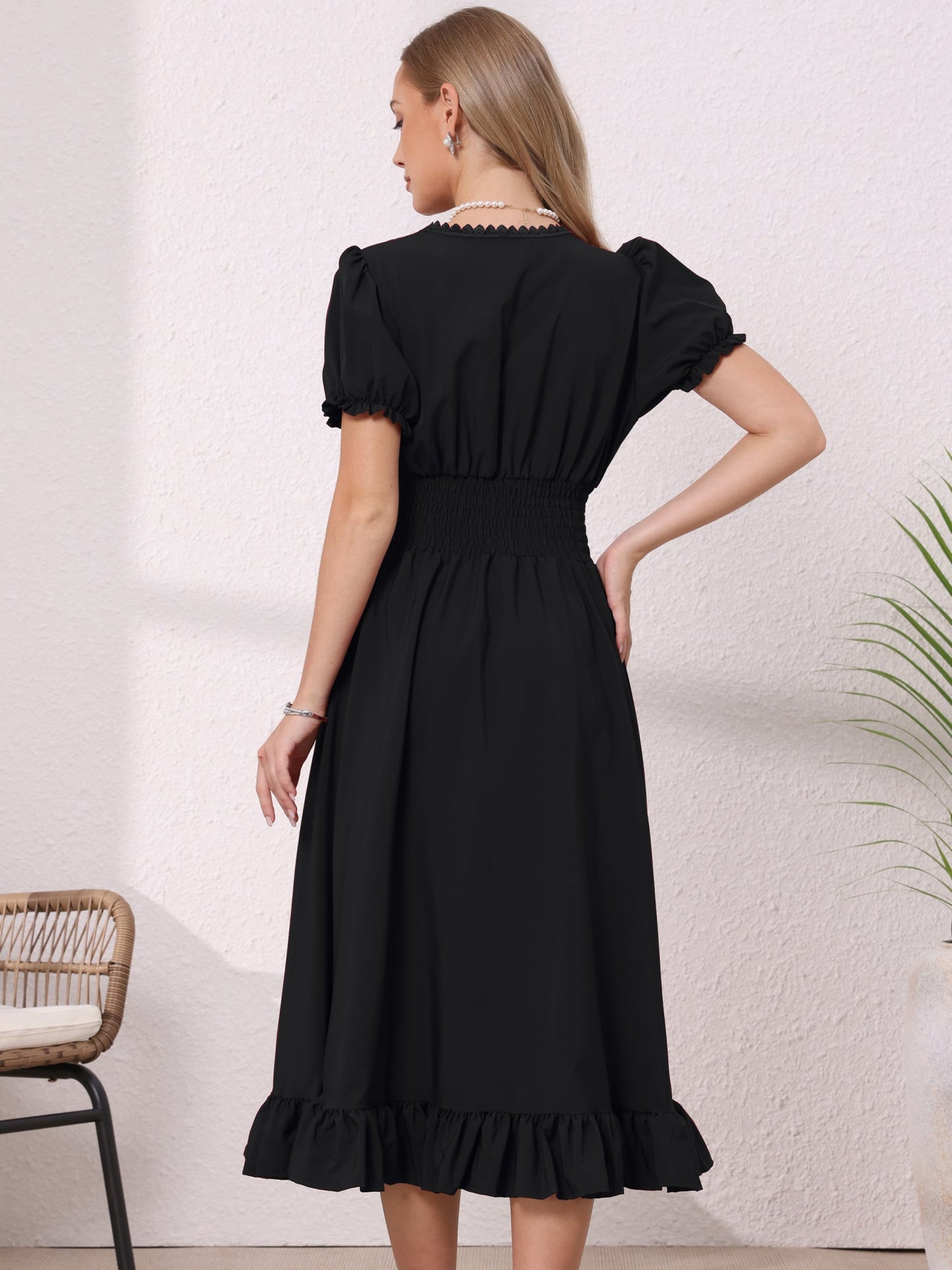 Black - Model wearing a solid woven midi dress featuring a square neckline, short puff sleeves, a wide smocked waist, and a dramatic ruched front with an asymmetrical ruffled hem.