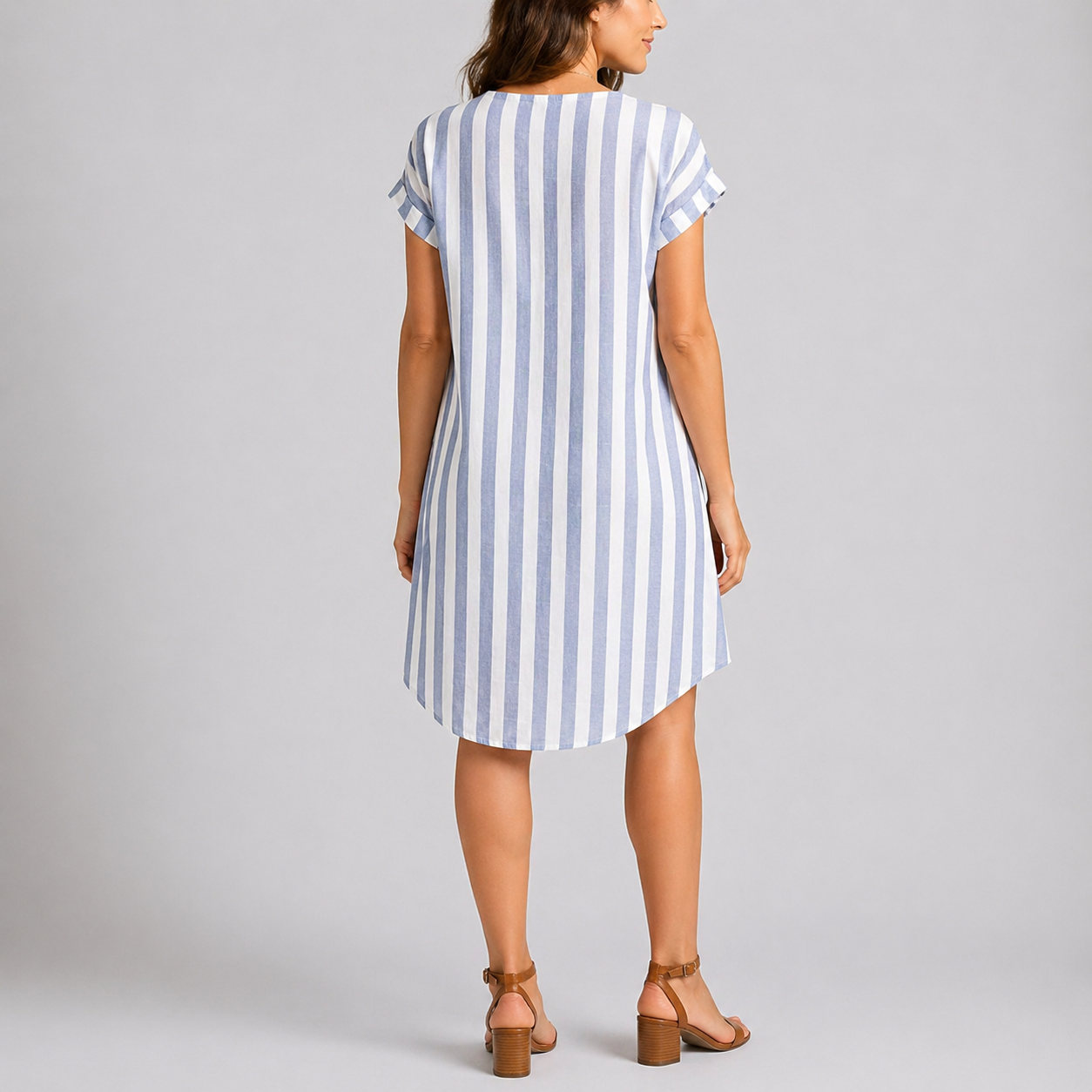 Blue - Woman wearing a striped short-sleeve knee-length shirt dress with a button-up front and side pockets on a plain grey background.