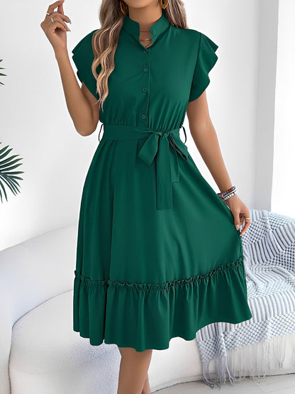Green - A woman wearing a woven short-sleeve midi shirt dress with a collared neckline, button-down front, tie waist, and tiered ruffle hem, holding a woven bag.