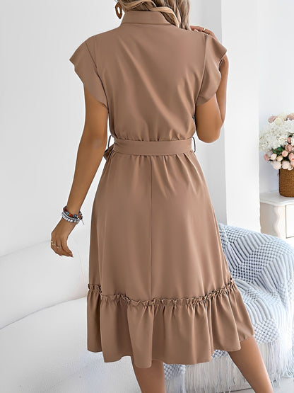 Khaki - A woman wearing a woven short-sleeve midi shirt dress with a collared neckline, button-down front, tie waist, and tiered ruffle hem, holding a woven bag.